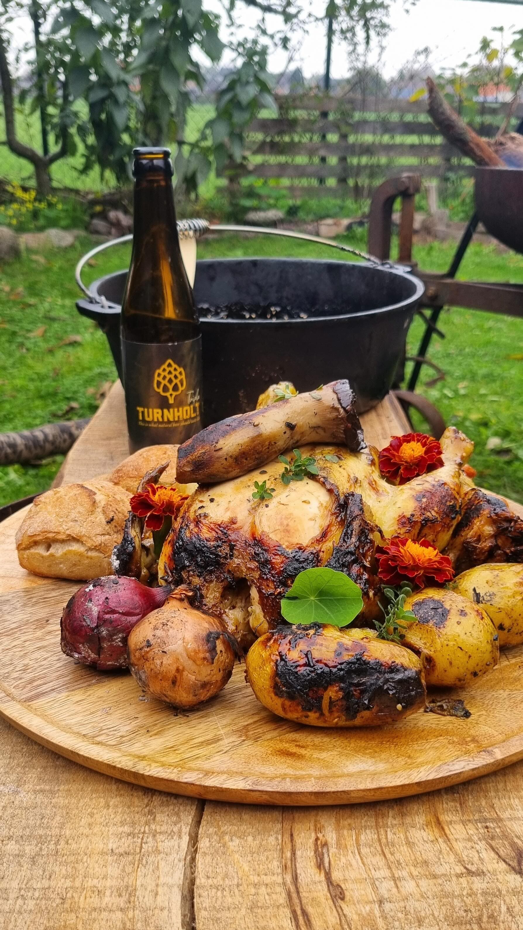 Boven open vuur gegrilde kip met een fles Turnholt Tripel